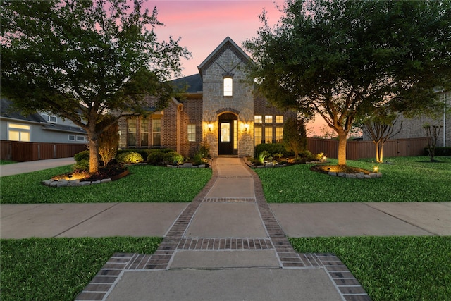 french provincial home with a lawn