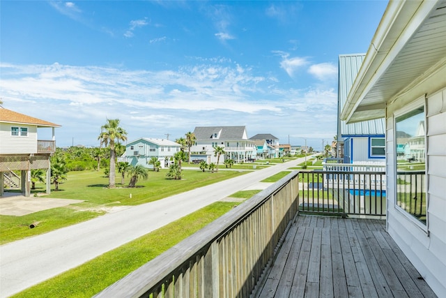 deck with a residential view and a lawn