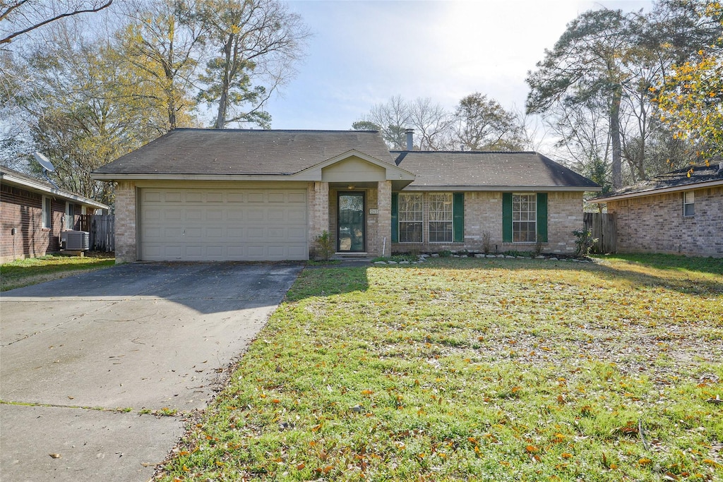 single story home with a garage, central AC, and a front yard