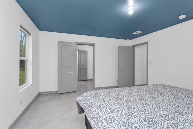 tiled bedroom featuring multiple windows