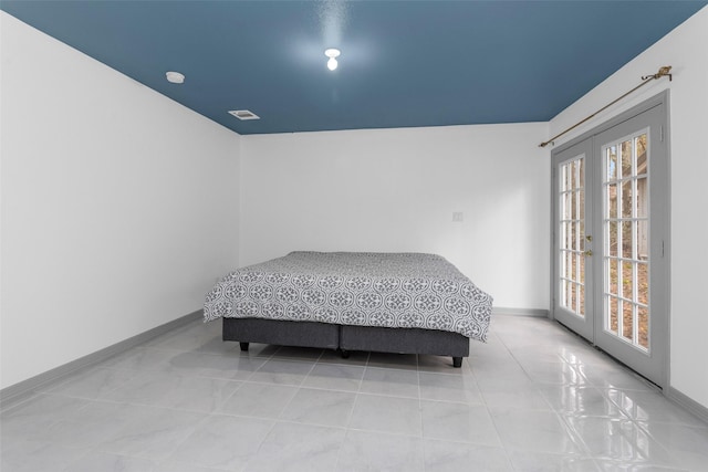 bedroom featuring light tile patterned floors, access to outside, and french doors