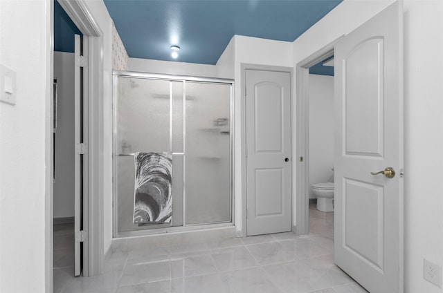 bathroom featuring toilet and an enclosed shower