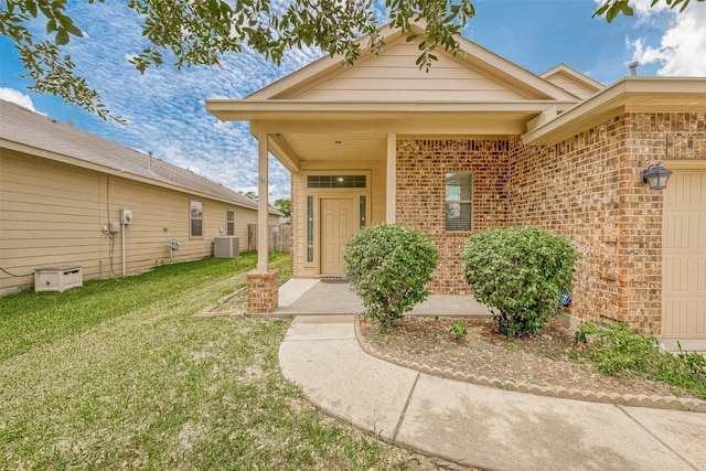 entrance to property with a yard and central air condition unit