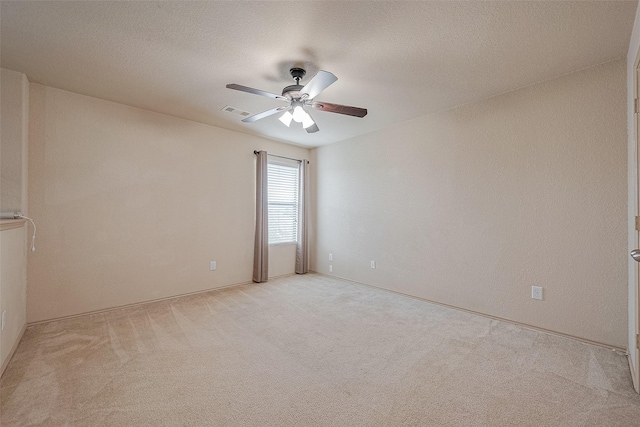 carpeted empty room featuring a textured ceiling and ceiling fan