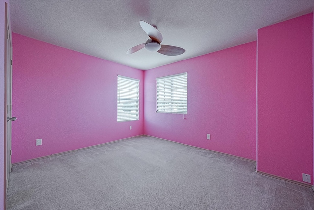 spare room with carpet, a textured ceiling, and ceiling fan