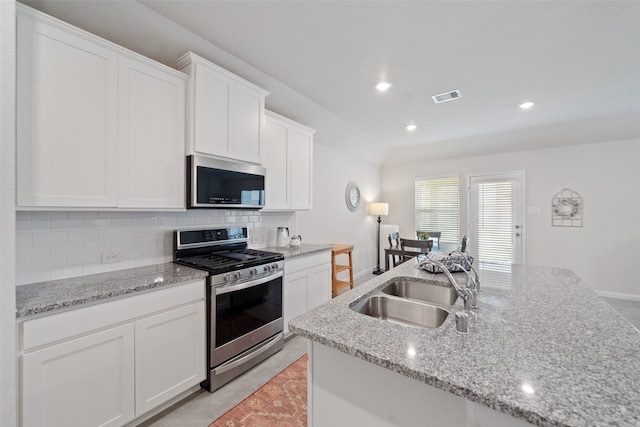 kitchen featuring light stone counters, stainless steel appliances, sink, and white cabinets