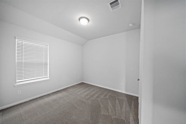 unfurnished room with vaulted ceiling and carpet flooring