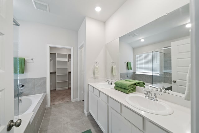 bathroom featuring tile patterned flooring, vanity, and shower with separate bathtub