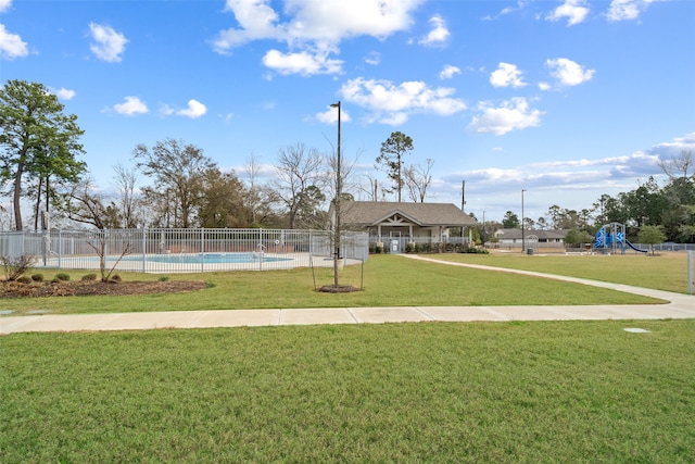 view of community featuring a yard, a playground, and a swimming pool