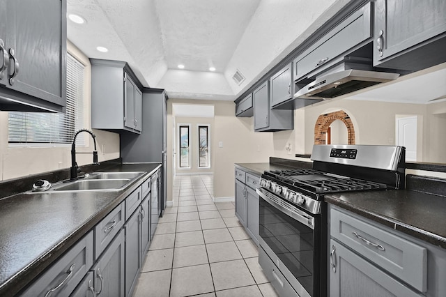 kitchen featuring sink, light tile patterned floors, gray cabinets, stainless steel appliances, and a raised ceiling