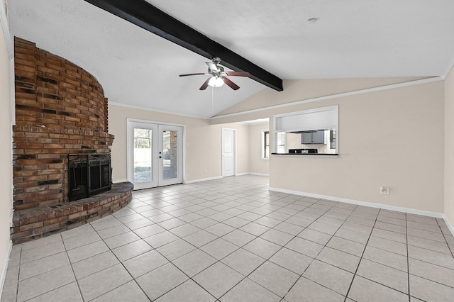 unfurnished living room with light tile patterned floors, ceiling fan, vaulted ceiling with beams, a brick fireplace, and french doors