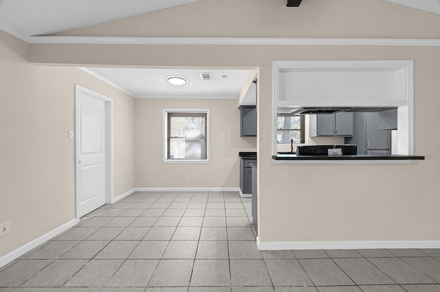 kitchen featuring crown molding, gray cabinets, vaulted ceiling, and light tile patterned floors