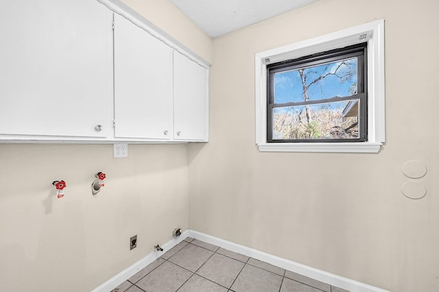 washroom featuring cabinets, hookup for a gas dryer, and light tile patterned floors