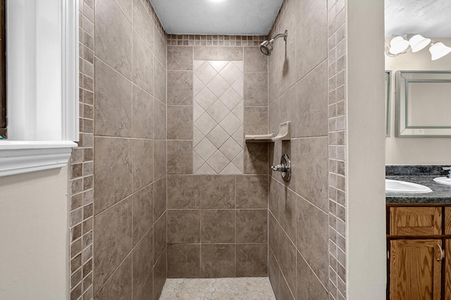 bathroom with vanity and a tile shower