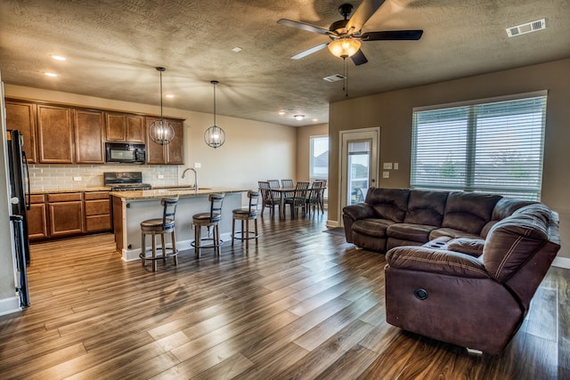 living room featuring sink, hardwood / wood-style flooring, and a textured ceiling