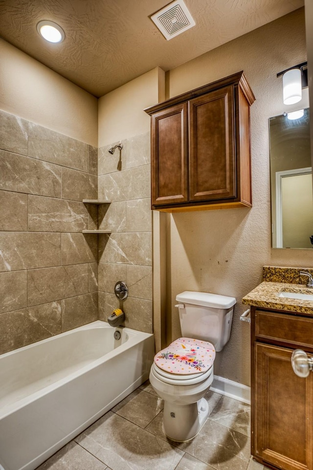 full bathroom with tiled shower / bath, vanity, and toilet