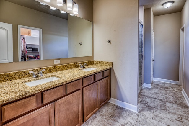 bathroom featuring a shower with door and vanity