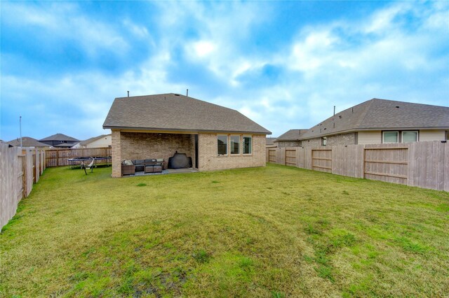 back of property with a yard and outdoor lounge area