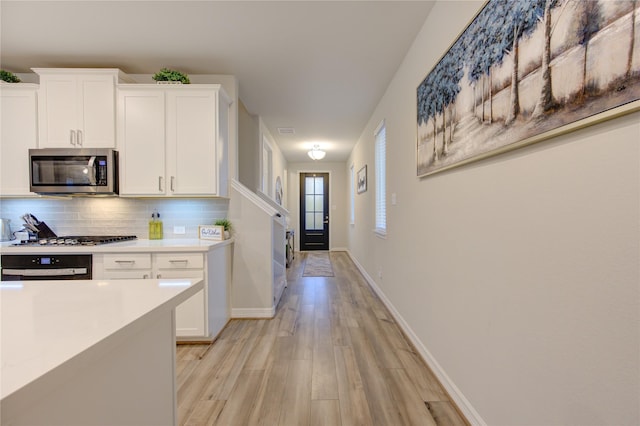 kitchen featuring white cabinetry, backsplash, and stainless steel appliances