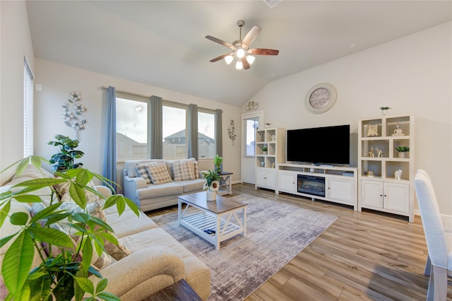 living room featuring lofted ceiling, ceiling fan, and light hardwood / wood-style flooring