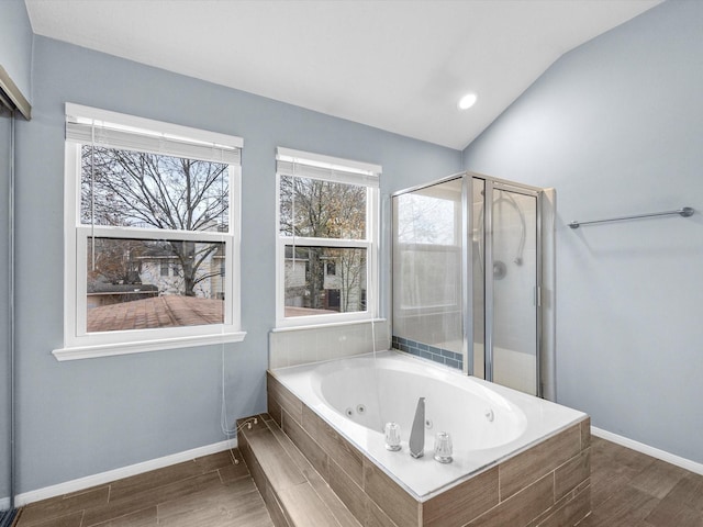 full bath featuring baseboards, a shower stall, a tub with jets, and wood finished floors