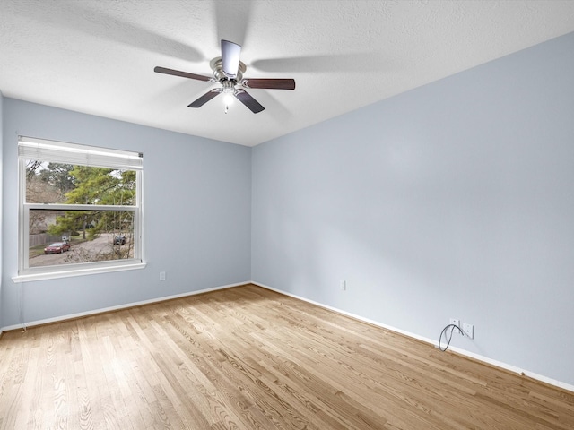 spare room with ceiling fan, light hardwood / wood-style floors, and a textured ceiling