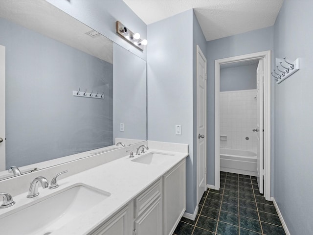 bathroom with tile patterned flooring, vanity, and a textured ceiling