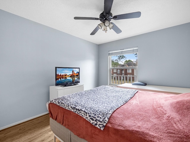 bedroom featuring ceiling fan, a textured ceiling, and light hardwood / wood-style flooring