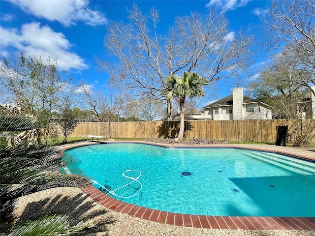 view of swimming pool featuring a diving board, a fenced backyard, and a fenced in pool