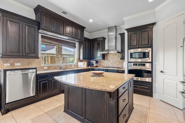 kitchen featuring wall chimney exhaust hood, sink, a center island, light tile patterned floors, and stainless steel appliances