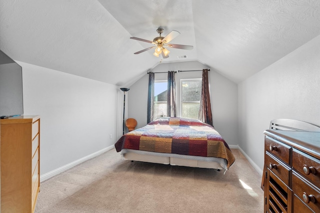 bedroom featuring ceiling fan, lofted ceiling, light colored carpet, and a textured ceiling