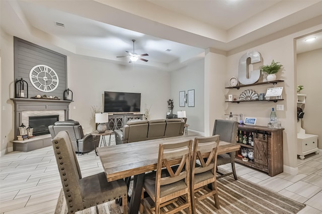 dining room with ceiling fan and a tray ceiling