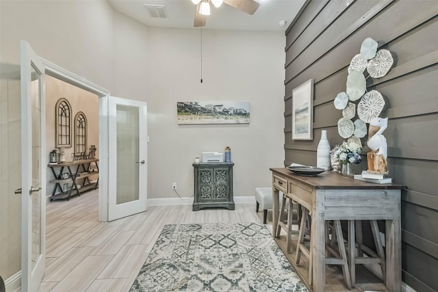 interior space with french doors, a towering ceiling, and light hardwood / wood-style flooring