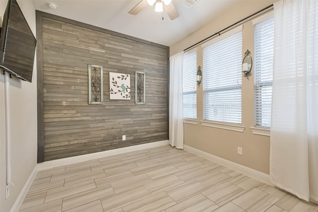 empty room with ceiling fan and wooden walls