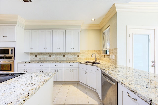 kitchen featuring light stone counters, sink, stainless steel appliances, and white cabinets