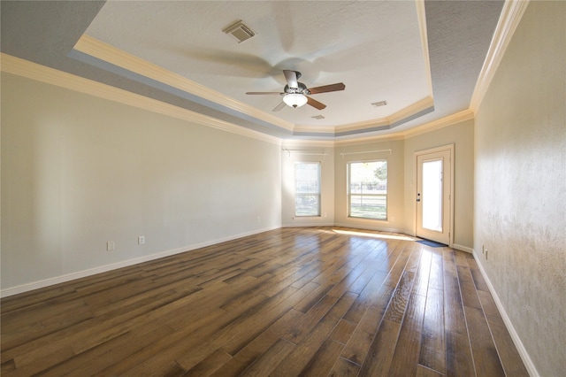 empty room with a raised ceiling, crown molding, ceiling fan, and dark hardwood / wood-style flooring