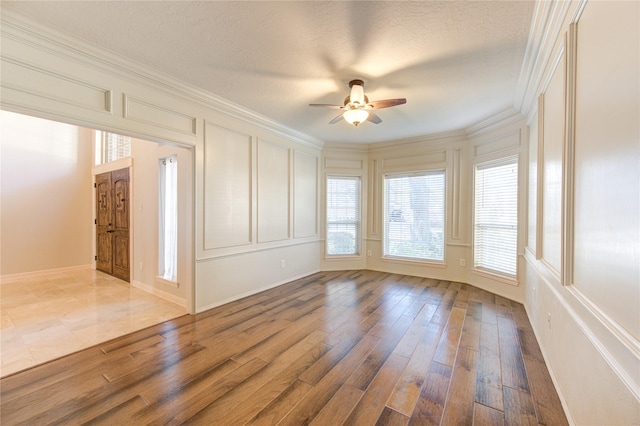 spare room featuring hardwood / wood-style flooring, crown molding, a textured ceiling, and ceiling fan