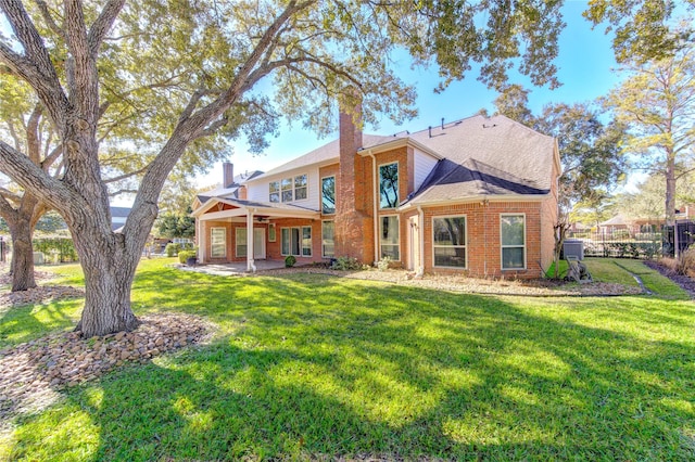 rear view of property featuring a patio area and a lawn