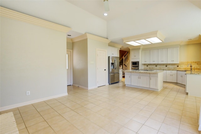 kitchen featuring light tile patterned floors, backsplash, stainless steel appliances, ornamental molding, and a kitchen island