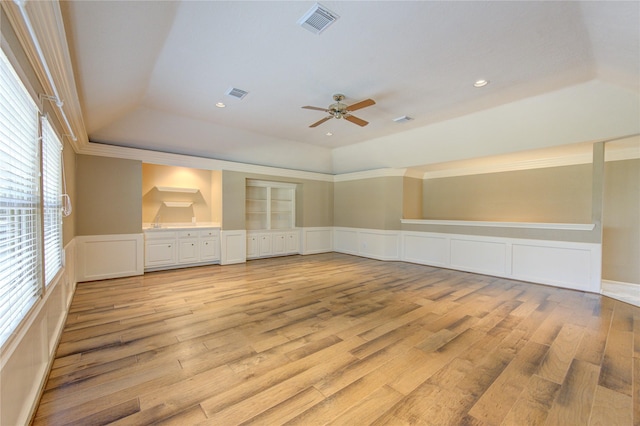 unfurnished living room with light hardwood / wood-style flooring, ceiling fan, and a tray ceiling