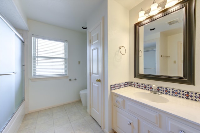 full bathroom featuring enclosed tub / shower combo, vanity, toilet, and tile patterned flooring