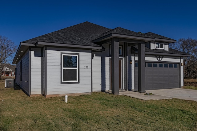 prairie-style house featuring cooling unit, a garage, and a front yard