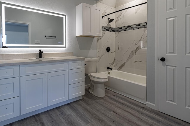 full bathroom with vanity, hardwood / wood-style floors, toilet, and tiled shower / bath