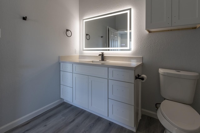 bathroom featuring vanity, hardwood / wood-style floors, and toilet