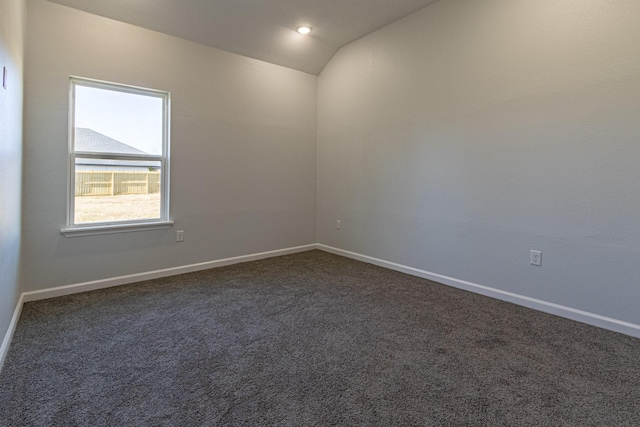 carpeted spare room featuring lofted ceiling