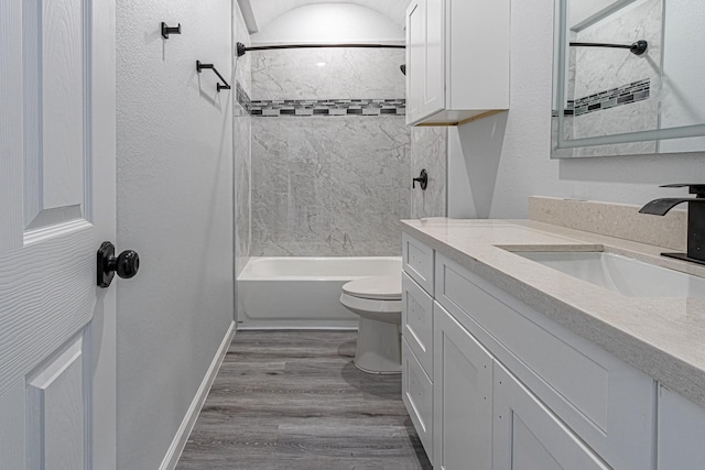 full bathroom with hardwood / wood-style flooring, vanity, toilet, and tiled shower / bath