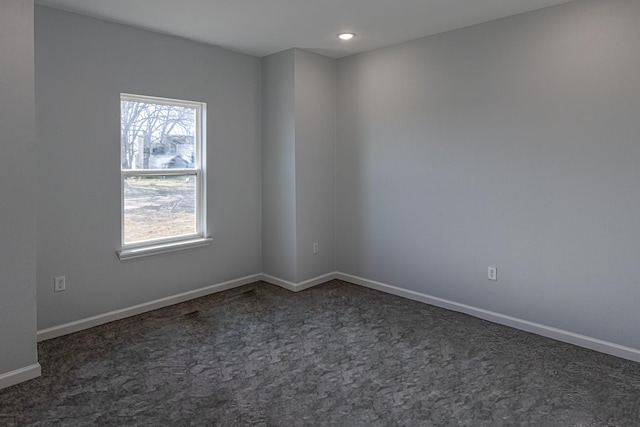 empty room with dark colored carpet