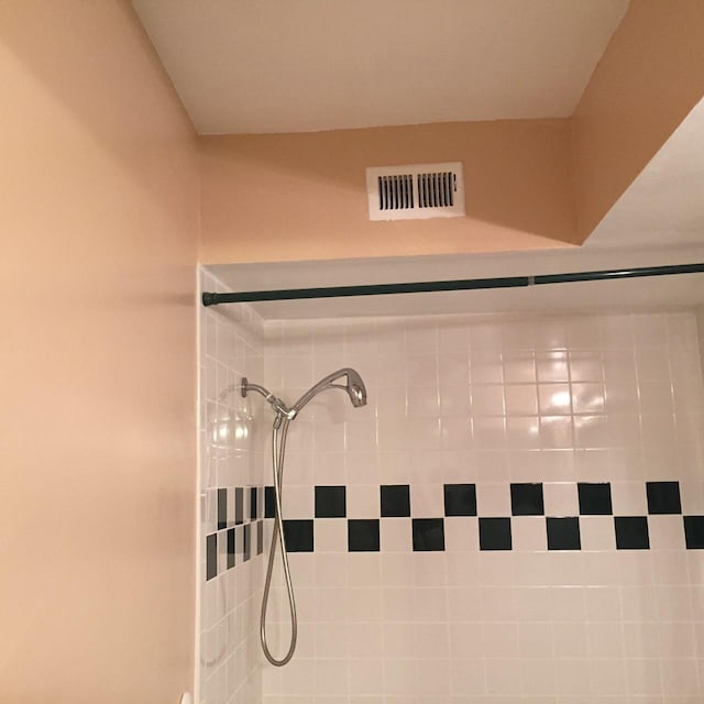 interior details featuring a tile shower