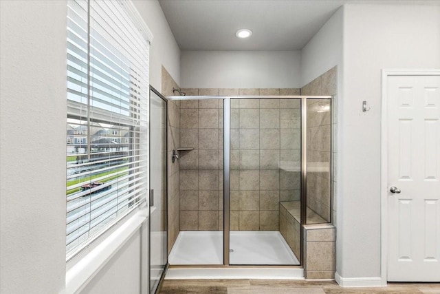 full bathroom with a shower stall and wood finished floors