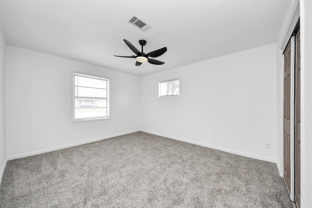 carpeted spare room with ceiling fan